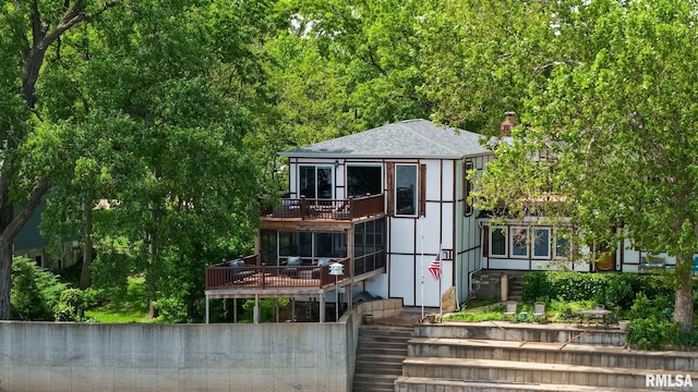 905 1st St, Camanche, IA 52730 - view of front of house featuring roof with shingles, a balcony, a deck, and stairs