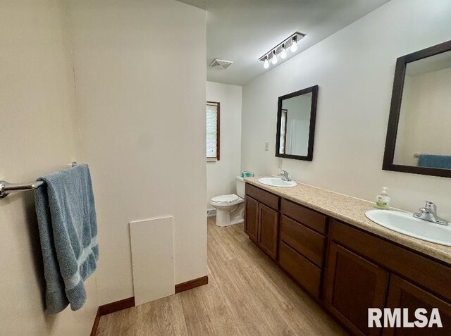 1492 45th St, New Boston, IL 61272 - full bath with wood finished floors, double vanity, toilet, and baseboards