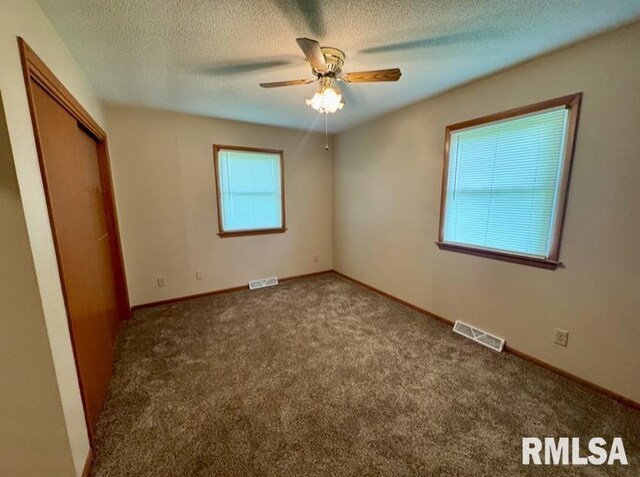1492 45th St, New Boston, IL 61272 - unfurnished bedroom with carpet, a textured ceiling, baseboards, a closet, and a ceiling fan