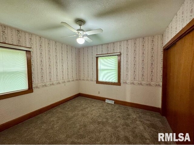 1492 45th St, New Boston, IL 61272 - unfurnished bedroom featuring a closet, carpet floors, ceiling fan, and a textured ceiling