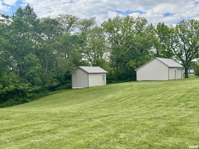 1492 45th St, New Boston, IL 61272 - view of grassy yard featuring an outbuilding, an outdoor structure, and view of wooded area