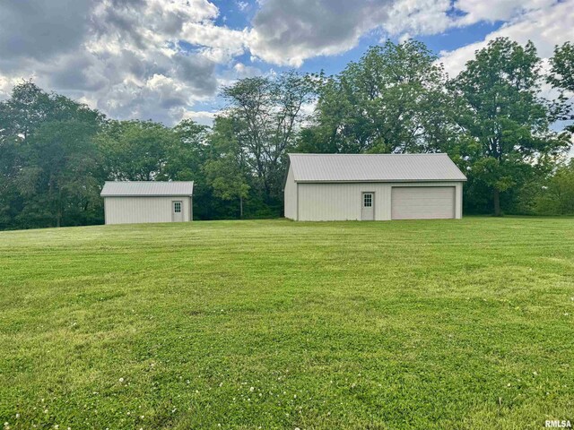 1492 45th St, New Boston, IL 61272 - view of green lawn featuring an outdoor structure, a garage, and an outbuilding
