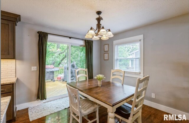 3071 S Hampton Dr, Bettendorf, IA 52722 - dining area with a chandelier, plenty of natural light, dark wood finished floors, and a textured ceiling
