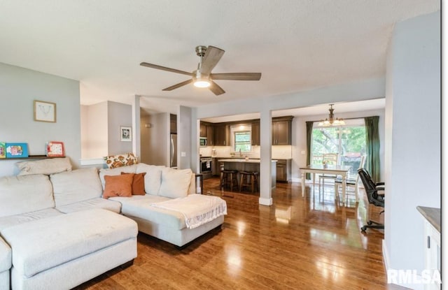 3071 S Hampton Dr, Bettendorf, IA 52722 - living room featuring wood finished floors, ceiling fan, and a chandelier