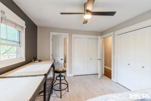 3071 S Hampton Dr, Bettendorf, IA 52722 - bedroom with two closets, light wood-style floors, baseboards, and ceiling fan