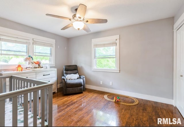 3071 S Hampton Dr, Bettendorf, IA 52722 - bedroom featuring baseboards, a crib, wood finished floors, and ceiling fan