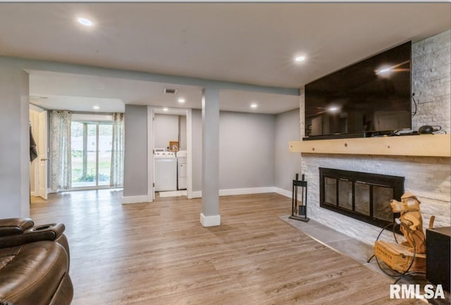 3071 S Hampton Dr, Bettendorf, IA 52722 - living room featuring separate washer and dryer, a stone fireplace, wood finished floors, and recessed lighting