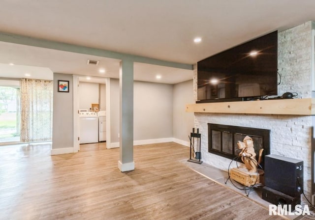 3071 S Hampton Dr, Bettendorf, IA 52722 - living area featuring washer and dryer, wood finished floors, recessed lighting, baseboards, and a stone fireplace