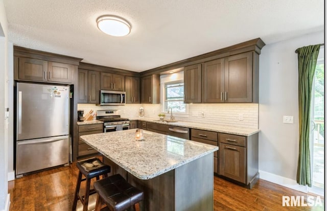 3071 S Hampton Dr, Bettendorf, IA 52722 - kitchen with stainless steel appliances, a sink, backsplash, dark wood-style flooring, and a textured ceiling