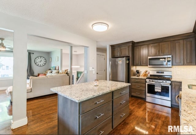 3071 S Hampton Dr, Bettendorf, IA 52722 - kitchen with appliances with stainless steel finishes, dark wood-type flooring, dark brown cabinets, and light stone counters