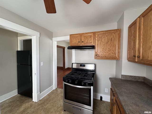 1122 E Colorado St, Davenport, IA 52803 - kitchen featuring stainless steel range with gas stovetop, freestanding refrigerator, a ceiling fan, under cabinet range hood, and dark countertops