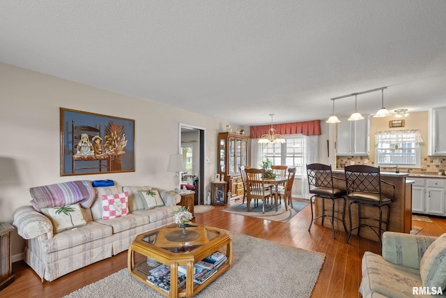 1415 W 59th St, Davenport, IA 52806 - living room with a chandelier, light wood-style floors, and a textured ceiling