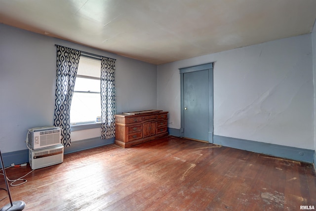 627 5th Ave S, Clinton, IA 52732 - empty room with hardwood / wood-style floors, baseboards, and a wall mounted AC