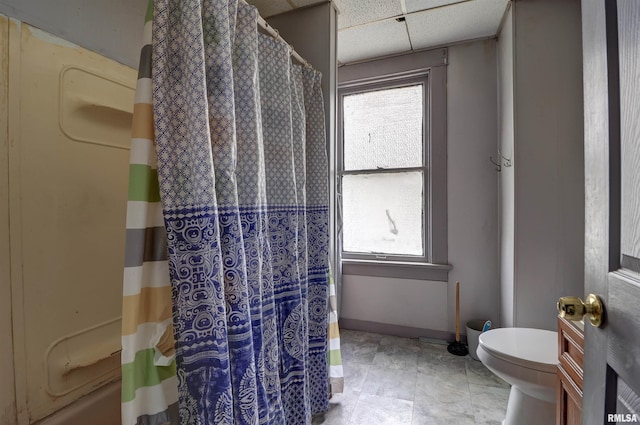 627 5th Ave S, Clinton, IA 52732 - bathroom featuring toilet, a drop ceiling, a shower with shower curtain, vanity, and baseboards
