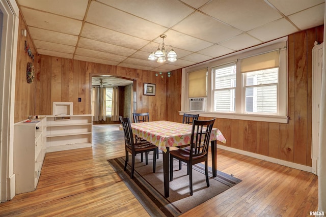 627 5th Ave S, Clinton, IA 52732 - dining room featuring wooden walls, a paneled ceiling, light wood-type flooring, a chandelier, and baseboards