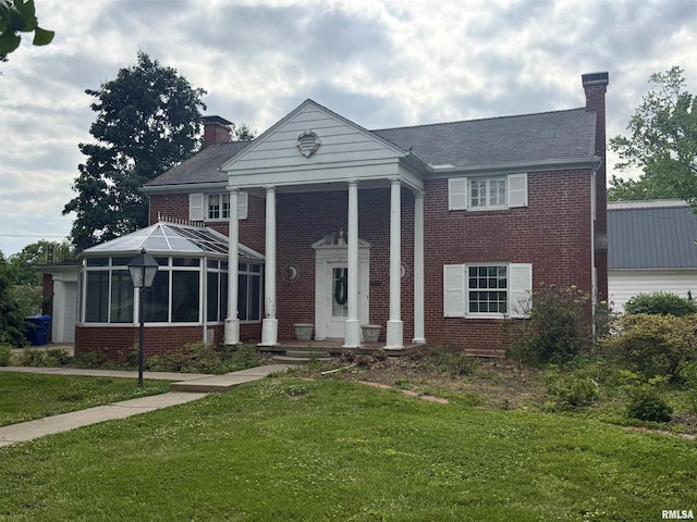 215 3rd St, Carmi, IL 62821 - greek revival inspired property with a chimney, brick siding, a front lawn, and a sunroom