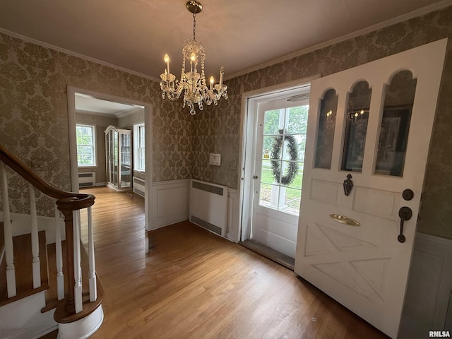 215 3rd St, Carmi, IL 62821 - entrance foyer with crown molding, light wood-style flooring, wainscoting, a chandelier, and wallpapered walls