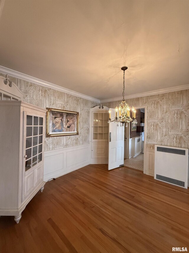215 3rd St, Carmi, IL 62821 - unfurnished dining area featuring a chandelier, radiator, wood finished floors, a decorative wall, and wallpapered walls