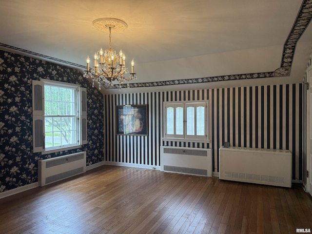 215 3rd St, Carmi, IL 62821 - empty room featuring radiator, wallpapered walls, hardwood / wood-style floors, a chandelier, and baseboards