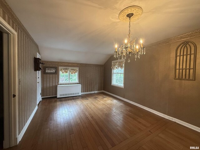 215 3rd St, Carmi, IL 62821 - unfurnished dining area with radiator, a chandelier, dark wood finished floors, vaulted ceiling, and wallpapered walls
