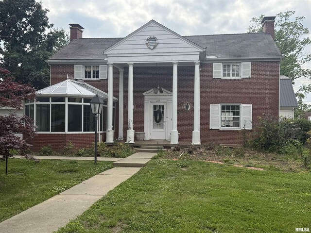 215 3rd St, Carmi, IL 62821 - greek revival inspired property with a chimney, brick siding, and a front yard