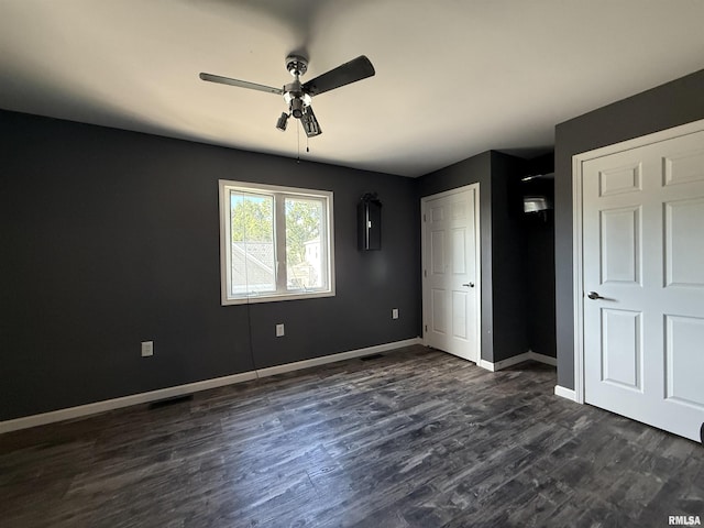 215 3rd St, Carmi, IL 62821 - unfurnished bedroom with dark wood-type flooring, baseboards, and a ceiling fan
