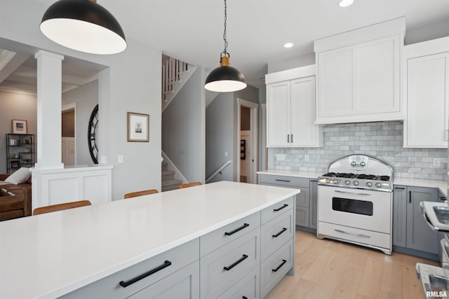 4691 Hidden Lake Ct, Bettendorf, IA 52722 - kitchen with white range with gas cooktop, decorative columns, gray cabinets, light countertops, and recessed lighting