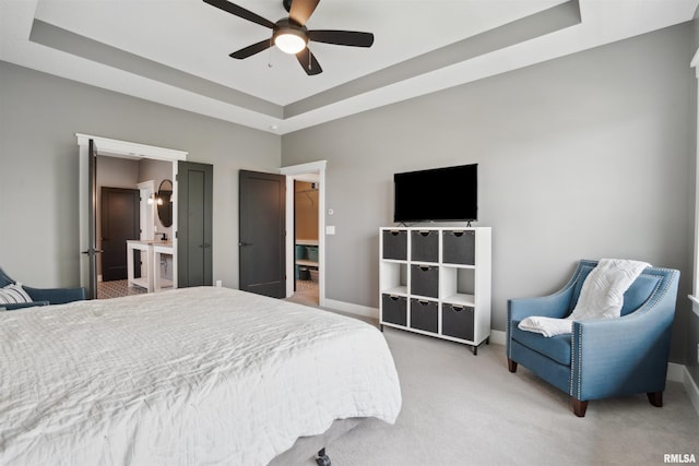 4691 Hidden Lake Ct, Bettendorf, IA 52722 - bedroom with light colored carpet, a tray ceiling, baseboards, a ceiling fan, and connected bathroom