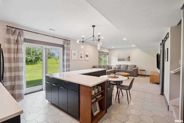 4691 Hidden Lake Ct, Bettendorf, IA 52722 - kitchen with light countertops, a barn door, a center island, hanging light fixtures, and recessed lighting