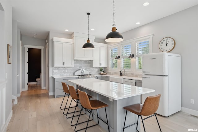 4691 Hidden Lake Ct, Bettendorf, IA 52722 - kitchen featuring white appliances, a breakfast bar area, a sink, backsplash, and recessed lighting