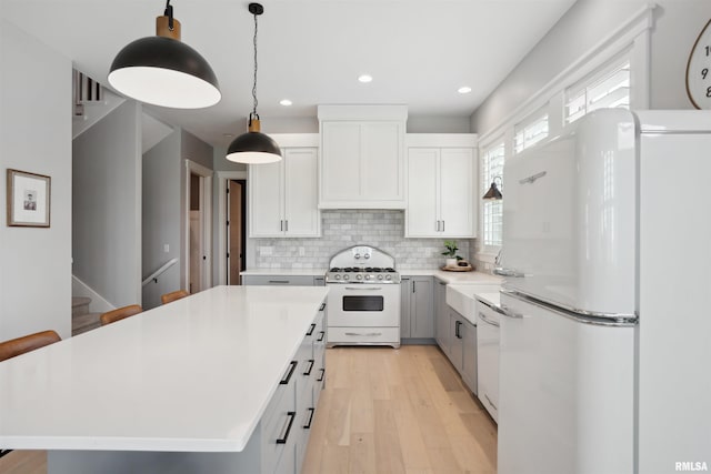 4691 Hidden Lake Ct, Bettendorf, IA 52722 - kitchen with white appliances, recessed lighting, a kitchen island, backsplash, and light countertops