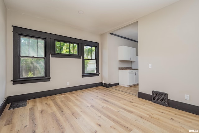 1522 Bridge Ave, Davenport, IA 52803 - empty room with plenty of natural light, light wood-style floors, and baseboards