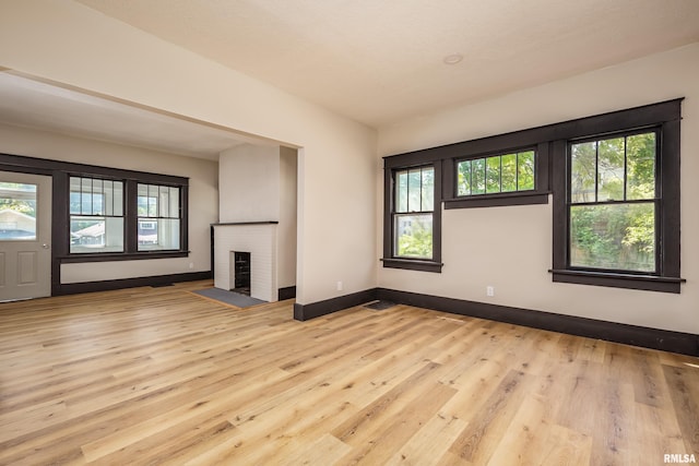 1522 Bridge Ave, Davenport, IA 52803 - unfurnished living room with healthy amount of natural light, wood finished floors, baseboards, and a fireplace
