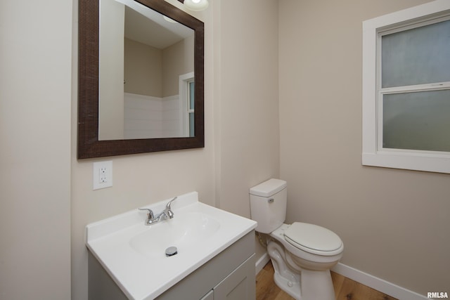 1522 Bridge Ave, Davenport, IA 52803 - bathroom featuring baseboards, vanity, toilet, and wood finished floors