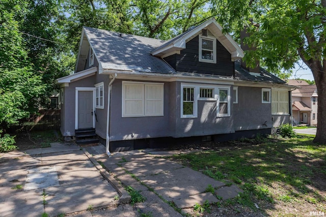 1522 Bridge Ave, Davenport, IA 52803 - view of front of property with entry steps, a shingled roof, and stucco siding