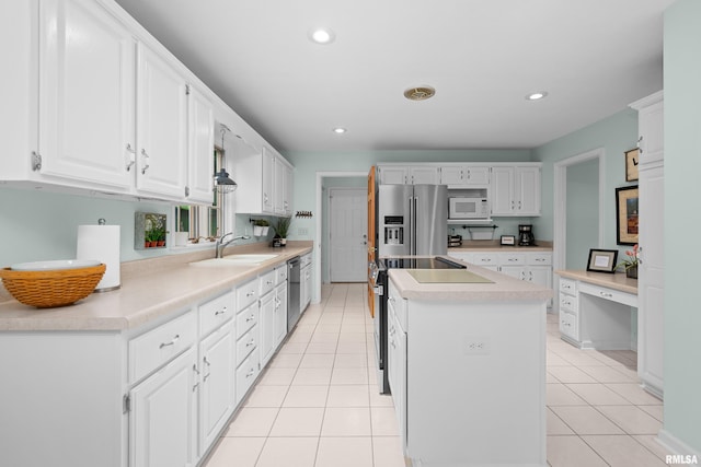 3513 33rd Street Ct, Moline, IL 61265 - kitchen with white microwave, stainless steel fridge, a sink, a kitchen island, and white cabinetry