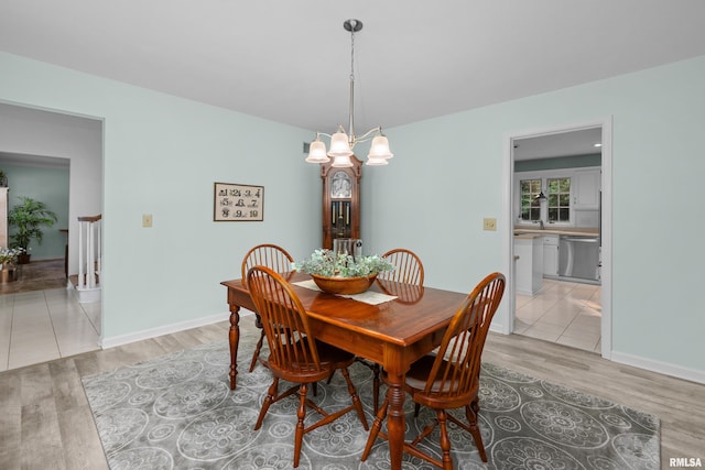 3513 33rd Street Ct, Moline, IL 61265 - dining space featuring light wood-style flooring, a chandelier, and baseboards