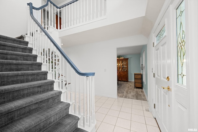 3513 33rd Street Ct, Moline, IL 61265 - foyer entrance featuring stairway, light tile patterned floors, high vaulted ceiling, and baseboards