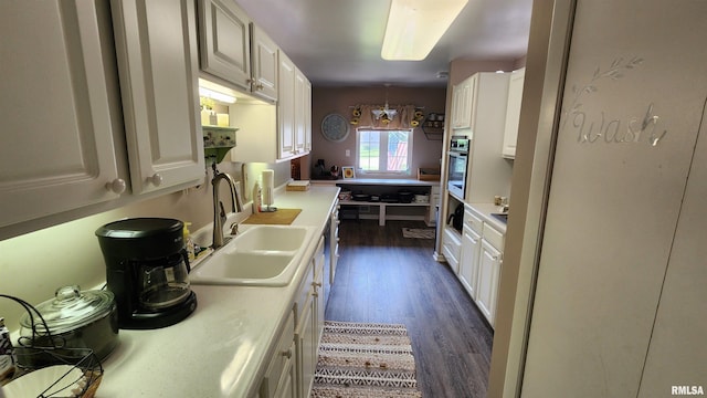 2606 4th Street Ct, East Moline, IL 61244 - kitchen with a sink, stainless steel oven, dark wood finished floors, light countertops, and white cabinets