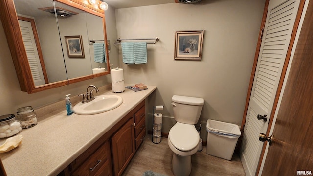 2606 4th Street Ct, East Moline, IL 61244 - bathroom with vanity, toilet, wood finished floors, a closet, and baseboards