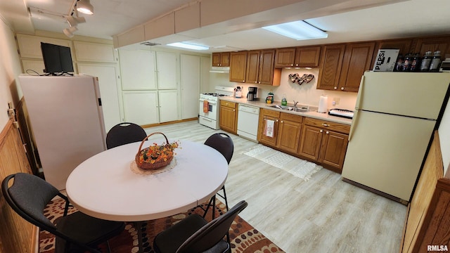 2606 4th Street Ct, East Moline, IL 61244 - kitchen featuring white appliances, light wood-style floors, a sink, light countertops, and brown cabinetry