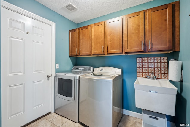 7318 35th Avenue Ct, Moline, IL 61265 - laundry area with washer and dryer, cabinet space, and a textured ceiling