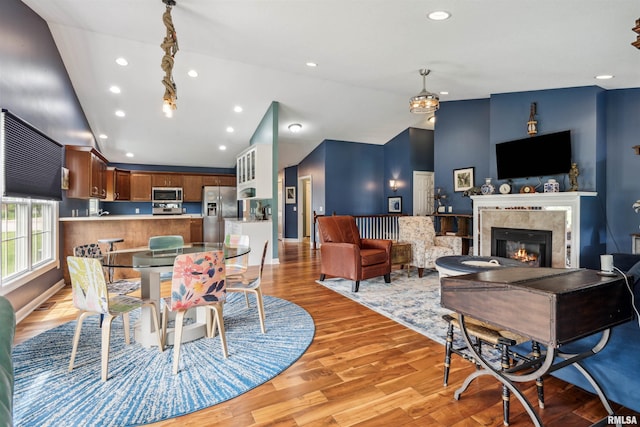 7318 35th Avenue Ct, Moline, IL 61265 - dining room with vaulted ceiling, light wood-style flooring, recessed lighting, a fireplace, and baseboards