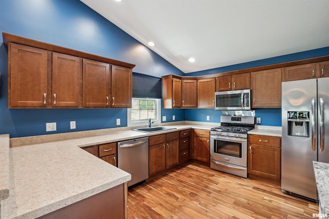 7318 35th Avenue Ct, Moline, IL 61265 - kitchen with stainless steel appliances, a sink, vaulted ceiling, light countertops, and light wood-type flooring