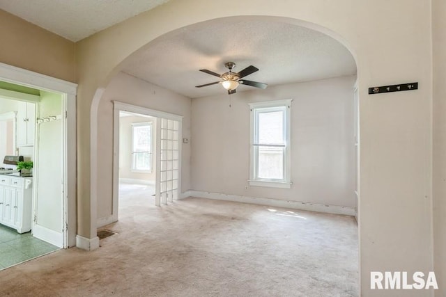 2308 18th Ave, Moline, IL 61265 - carpeted empty room with arched walkways, a ceiling fan, plenty of natural light, and a textured ceiling