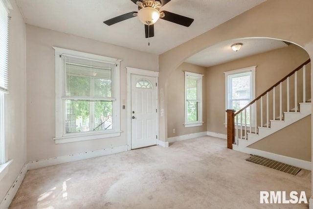 2308 18th Ave, Moline, IL 61265 - entryway featuring arched walkways, carpet flooring, baseboards, ceiling fan, and stairs