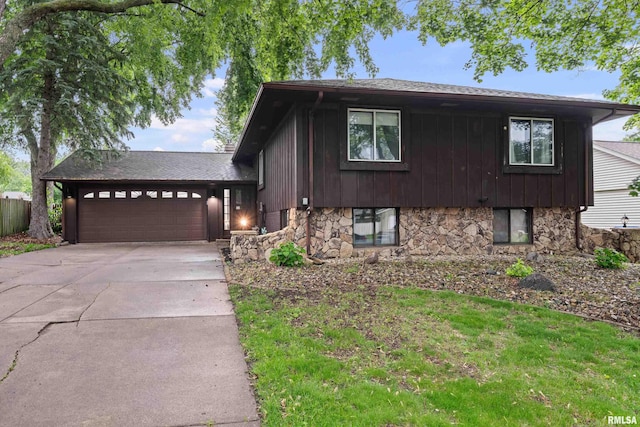 5721 Taylor St, Davenport, IA 52806 - tri-level home featuring a garage, stone siding, and concrete driveway