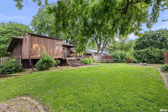 5721 Taylor St, Davenport, IA 52806 - view of yard featuring a trampoline and a wooden deck