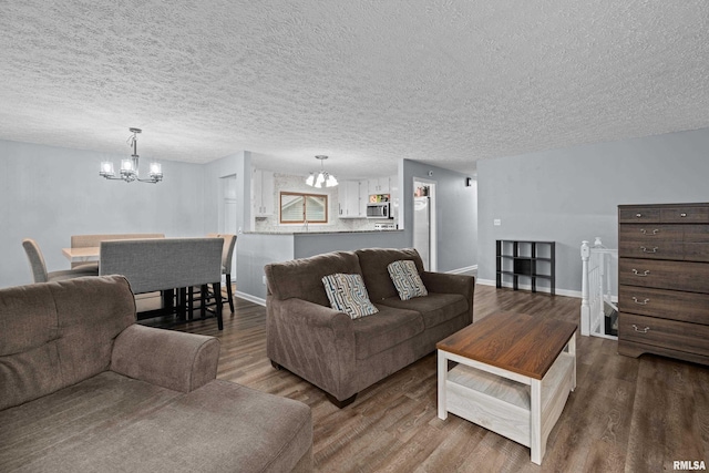 5721 Taylor St, Davenport, IA 52806 - living area featuring a chandelier, dark wood-style flooring, a textured ceiling, and baseboards