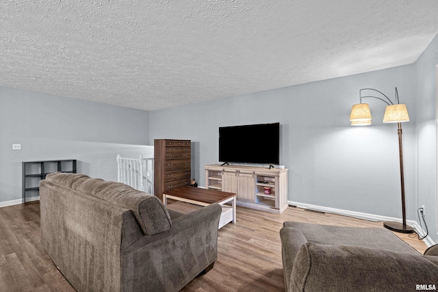 5721 Taylor St, Davenport, IA 52806 - living room featuring wood finished floors, a textured ceiling, and baseboards